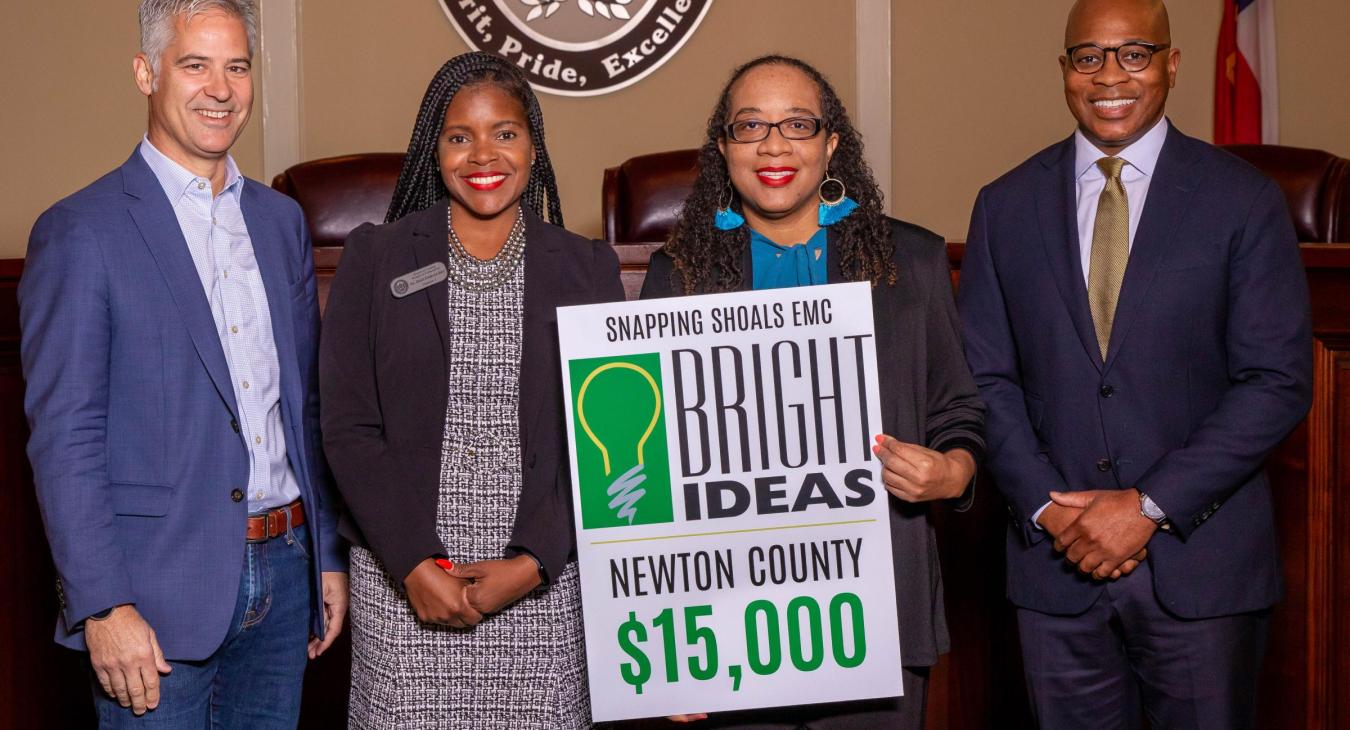 Newton Bright Ideas officials holding up sign